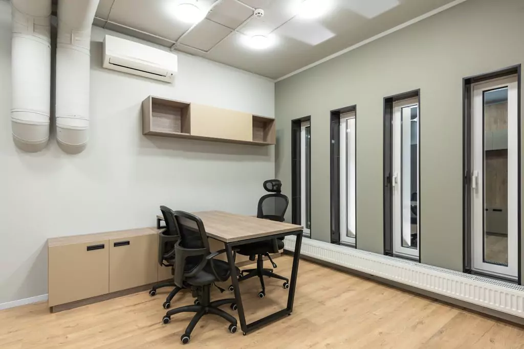 Home office with air conditioner illustrating AC energy saver mode versus cool mode for energy saving and comfort