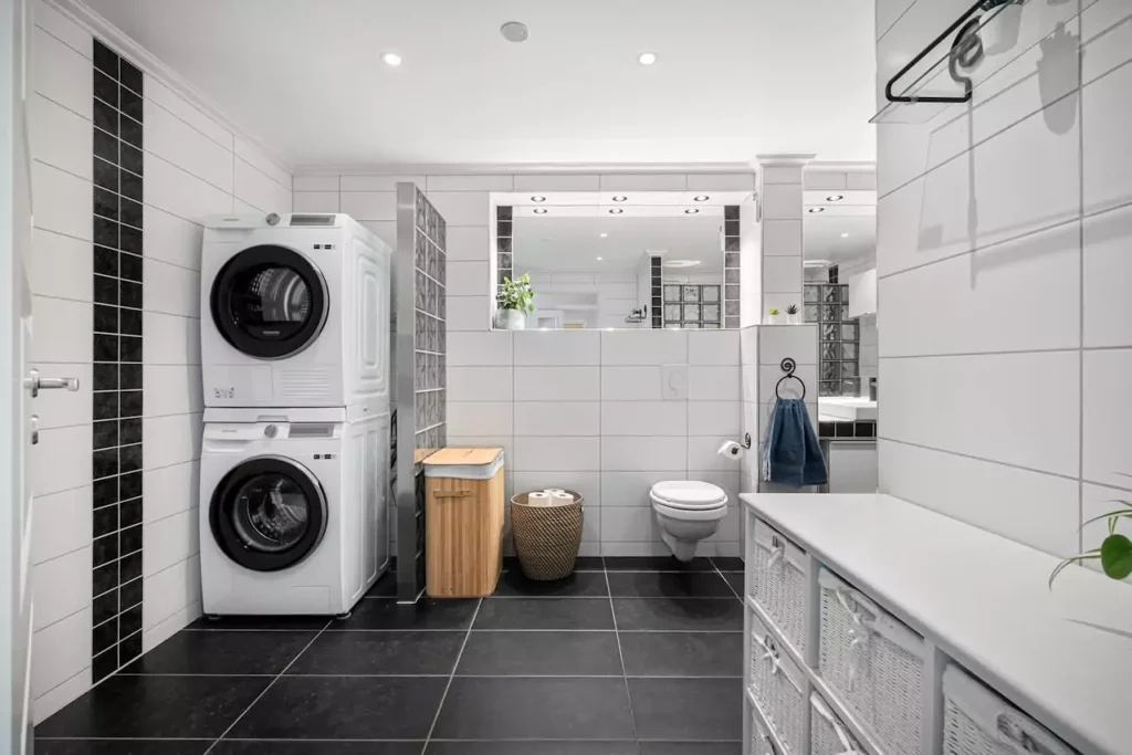 stacked washer and dryer in a modern laundry room with proper hookups and enough space for ventilation